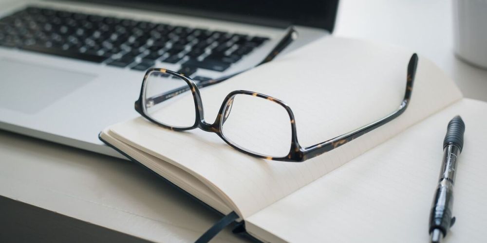 Okulary leżące na notesie podczas szkolenia.